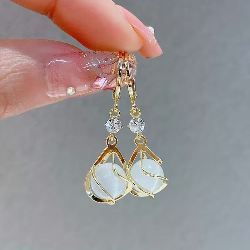 Boucles d'oreilles pendantes élégantes avec pompon et pierre